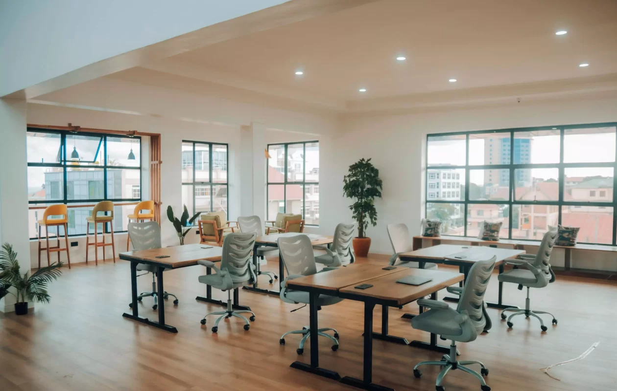 Sunlit shared desks and green chairs at Link Space Arusha